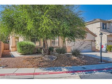 Charming home exterior with desert landscaping, mature tree, and well-maintained front yard at 7515 Splashing Rock Dr, Las Vegas, NV 89131