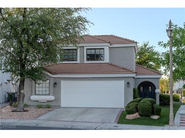 Charming home featuring a two-car garage, tile roof, and mature landscaping at 8740 Captains Pl, Las Vegas, NV 89117
