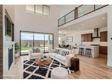 Open-concept living space with a modern kitchen, plush seating, and seamless indoor-outdoor flow at 182 Robledo St, Las Vegas, NV 89138