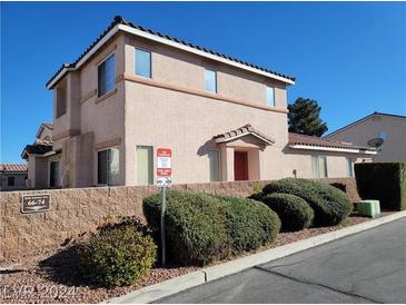 Tan two-story townhome featuring a tile roof, manicured shrubbery, and a no-parking sign at 70 Belle Essence Ave, Las Vegas, NV 89123