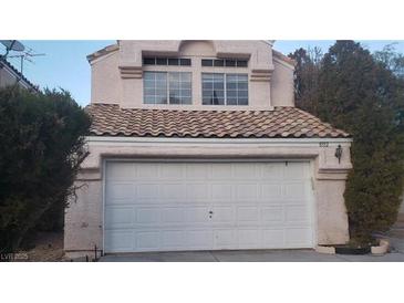 Charming home featuring a two-car garage and lush, mature landscaping at 8332 Shore Breeze Dr, Las Vegas, NV 89128