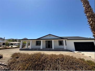 Charming single-story home with a covered porch, black trim, and an attached garage at 1227 San Gabriel Ave, Henderson, NV 89002