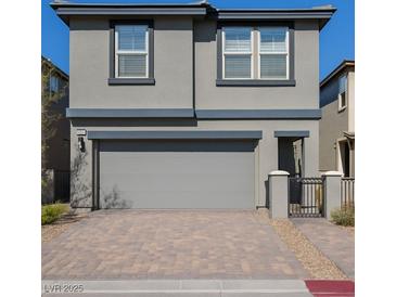 Charming two-story home featuring a gray exterior, garage, and a paved driveway at 12525 Lylan Ridge St, Las Vegas, NV 89138