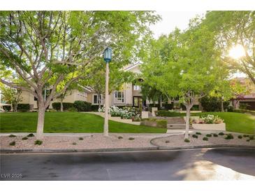 Inviting home exterior with manicured lawn, mature trees, and flowering plants at 1809 White Hawk Ct, Las Vegas, NV 89134