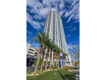 Modern high-rise condo building with stunning architecture and palm trees against a blue sky at 200 W Sahara Ave # 3510, Las Vegas, NV 89102