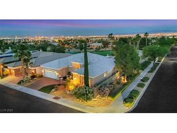 Breathtaking aerial view of the home, golf course, and Las Vegas city lights in the background at 4286 Pacifico Ln, Las Vegas, NV 89135