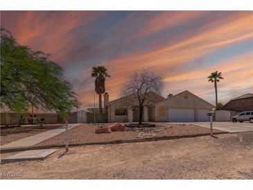 Charming single-story home featuring desert landscaping, a two-car garage, and a picturesque sunset at 475 E Robindale Rd, Las Vegas, NV 89123