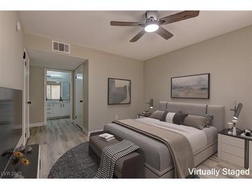 Comfortable bedroom featuring a ceiling fan, neutral walls, and ensuite bathroom with a spacious countertop at 5710 E Tropicana Ave # 1216, Las Vegas, NV 89122