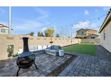 Inviting backyard featuring a cozy lounge area and a well-maintained lawn, perfect for relaxation and entertaining at 6318 Amber Sunrise St, North Las Vegas, NV 89031