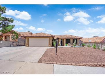 Charming single-story home featuring a tile roof, desert landscaping, and a two-car garage at 903 Billings St, Henderson, NV 89002