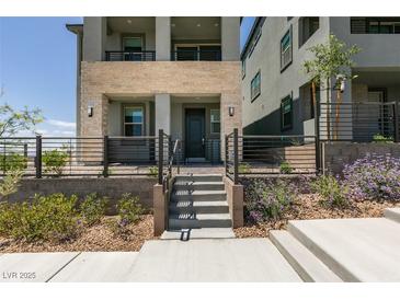 Contemporary three-story home with a stone facade and front yard landscaping at 11552 Ashy Storm Ave, Las Vegas, NV 89138