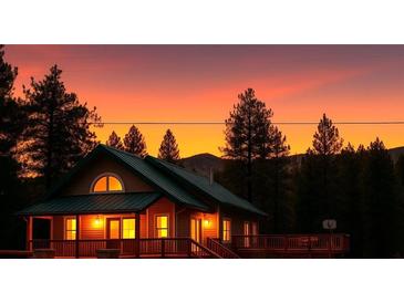 Charming cabin-style home with a green metal roof and a wraparound deck against a fiery sunset backdrop at 4178 Matterhorn Way, Las Vegas, NV 89124
