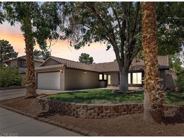 Charming single-story home featuring a well-manicured lawn, desert landscaping, and a two-car garage at 6436 Vinecrest Ave, Las Vegas, NV 89108