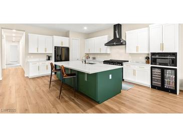 Modern kitchen featuring white cabinets, a green island with a white countertop, and stainless steel appliances at 10906 Mila Landing Ave, Las Vegas, NV 89166