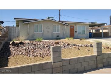 Charming single-story home with a rock-landscaped front yard, carport, and neutral color palette at 129 Maple St, Henderson, NV 89015