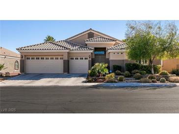 Charming single-story home featuring a three-car garage, desert landscaping, and a tile roof at 2713 Tanagrine Dr, North Las Vegas, NV 89084