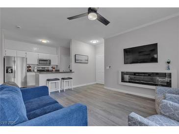 Bright living space featuring sleek gray floors, a modern fireplace, and an open kitchen at 2900 Sunridge Heights Pkwy # 1916, Henderson, NV 89052