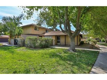 Inviting two-story home featuring a well-maintained lawn and mature trees offering shade at 5083 Village Dr, Las Vegas, NV 89142