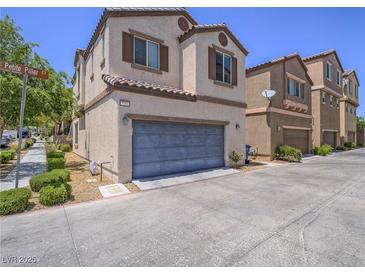 Charming townhome with a gray garage door, desert landscaping, and a well-kept exterior at 7753 Petite Pillar Ct, Las Vegas, NV 89149