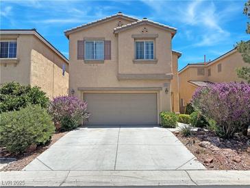 Charming two-story home with a two-car garage and beautiful landscaping, including flowering bushes at 9034 Grenache St, Las Vegas, NV 89148