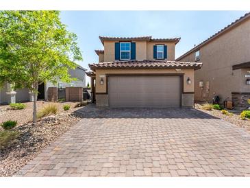 Inviting two-story home featuring a brick driveway, charming shutters, and a spacious two-car garage at 9690 Langden Brook St, Las Vegas, NV 89178