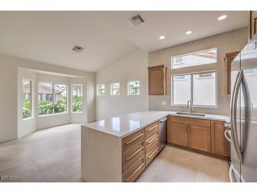 Bright kitchen features an island, stainless steel appliances, and a breakfast nook overlooking the landscaped backyard at 10421 Linfield Pl, Las Vegas, NV 89134
