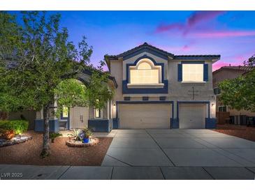 Inviting two-story home with a well-manicured lawn, complemented by a wide driveway leading to a two-car garage at 2717 Cool Lilac Ave, Henderson, NV 89052
