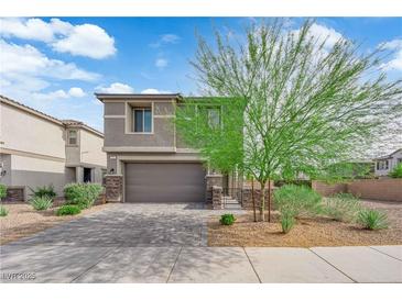 Charming two-story home featuring a well-manicured yard and a two-car garage on a beautiful, sunny day at 311 Lilian Faith Ave, North Las Vegas, NV 89031