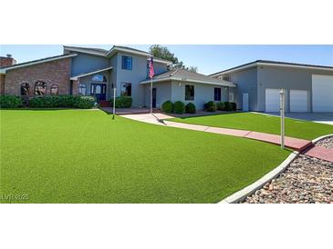 Charming two-story home with well manicured artificial turf, long driveway, and lush landscaping at 4075 E Oquendo Rd, Las Vegas, NV 89120
