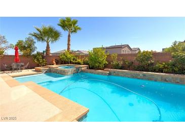 Inviting backyard pool and spa area perfect for outdoor relaxation and entertaining with lush landscaping at 6403 Brandon Hills Ct, Las Vegas, NV 89139