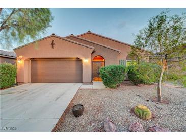 Charming single-story home featuring desert landscaping, a two-car garage, and an inviting arched entryway at 7235 Summer Air Ave, Las Vegas, NV 89179