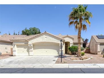 Inviting single-story home featuring a three-car garage and desert landscaping at 7544 Coral River Dr, Las Vegas, NV 89131