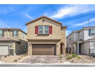 Charming two-story home featuring a brick driveway, two-car garage, red shutters, and low-maintenance landscaping at 9114 Riverlands Ranch St, Las Vegas, NV 89139