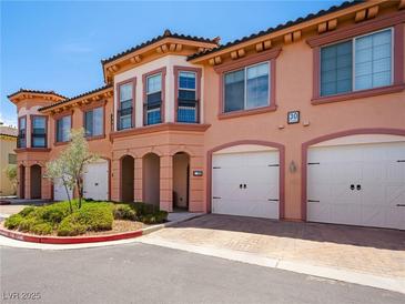 Charming townhome with a two-car garage, manicured landscaping, and covered entryway in a desirable community at 30 Via Vasari # 103, Henderson, NV 89011