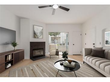 Bright living room featuring fireplace, modern furnishings, and sliding doors for natural light at 3318 N Decatur Blvd # 1020, Las Vegas, NV 89130