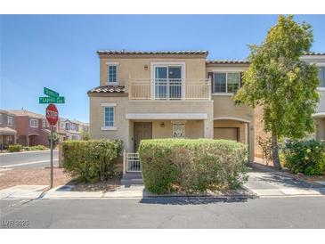 Inviting two-story home with a balcony, attached garage, and manicured landscaping at 6217 Lapilli Ave, Las Vegas, NV 89139