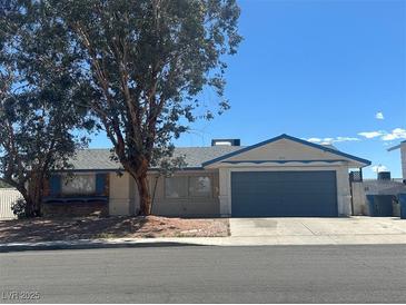 Charming single-story home featuring a two-car garage, a lush tree in the front yard, and a blue and beige color scheme at 6905 Singing Dunes Ln, Las Vegas, NV 89145