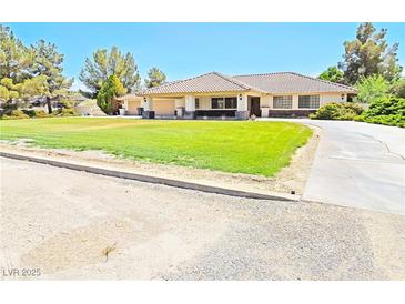 Spacious single-story home featuring a large front yard and a covered parking area at 731 W Calvada Blvd, Pahrump, NV 89048