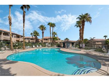 Community swimming pool with palm trees and blue skies on a sunny day, perfect for relaxation and recreation at 8410 Eldora Ave # 2046, Las Vegas, NV 89117