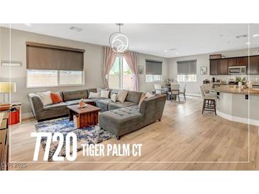 Open-concept living room with a large sectional sofa, wood floors, and a view of the kitchen at , Las Vegas, NV 89139