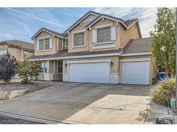 Two-story home with a three-car garage and a well-manicured front yard featuring desert landscaping at 104 Glendive St, Henderson, NV 89012