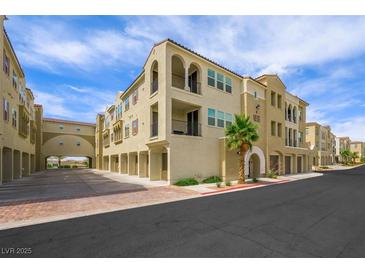 Beautiful stucco condo building featuring arched entrances and balconies, set against a sunny sky at 2555 Hampton Rd # 9307, Henderson, NV 89052