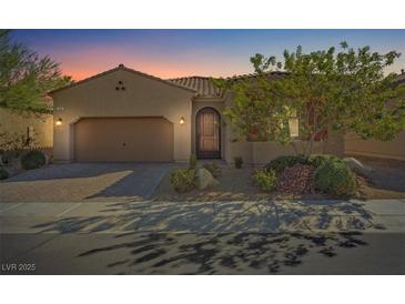 Charming single-story home featuring a desert landscape, and a two car garage at sunset at 305 Via Del Duomo, Henderson, NV 89011