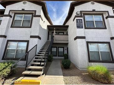 Exterior of a two-story apartment building featuring multiple windows and a central staircase leading to upper units at 45 Maleena Mesa St # 1321, Henderson, NV 89074