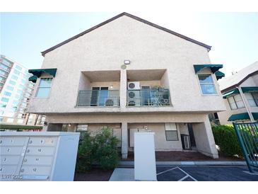 Two-story condo featuring a balcony with green awning and stucco exterior finish at 450 Elm Dr # 105, Las Vegas, NV 89169