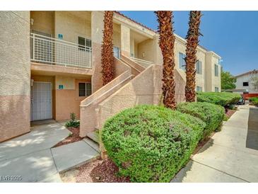 Charming condo exterior with landscaped walkway, stairs, and courtyard featuring mature palm trees at 5000 Red Rock St # 248, Las Vegas, NV 89118