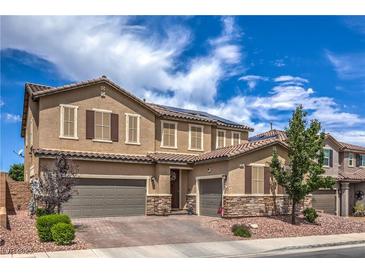 Beautiful two-story home with a three-car garage, stone accents, and well-manicured landscaping at 689 Sea Star St, Henderson, NV 89002