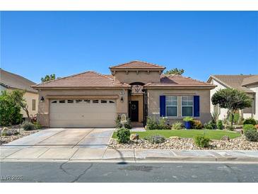 Charming single-story home featuring a desert landscape, an attached garage and a well-manicured lawn at 724 Smokey Mountain Ave, Henderson, NV 89012