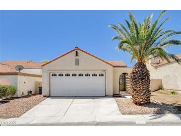 Charming one-story home with a two car garage and a mature palm tree in the front yard at 8233 Willeta Ave, Las Vegas, NV 89145