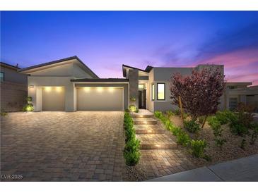 Stunning modern home with a three-car garage, beautiful landscaping, and a welcoming front entrance at 5166 Stone View Dr, Las Vegas, NV 89135